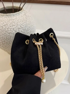 Chic black corduroy bucket bag with golden chain strap and elegant pearl charm detail
