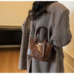 Détail d'un sac seau en cuir marron brillant avec fermoir rotatif argenté élégant