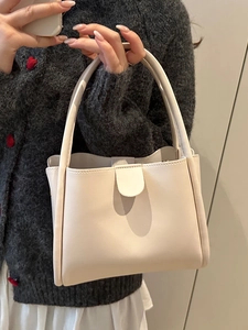 Minimalist cream white leather bucket bag for office commute featuring a top handle design