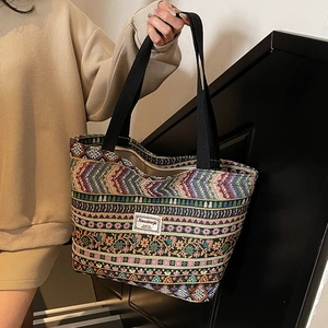 Ethnic woven canvas tote bag with floral jacquard texture and long black shoulder straps