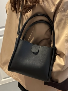 Minimalist black lychee pattern bucket bag with top handles and shoulder strap for women