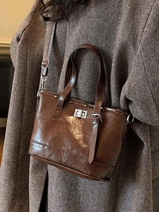 Sac seau en cuir marron brillant avec fermoir argenté et bandoulière réglable