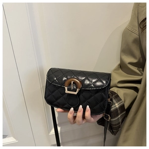 Close-up of quilted black leather crossbody bag with vintage wood grain buckle detail
