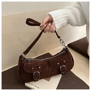 Detailed view of brown suede underarm bag with double front pockets and metal buckles