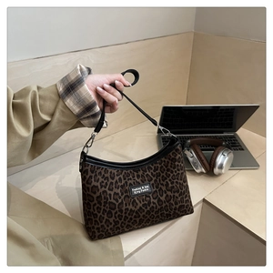 Détail du sac fourre-tout léopard avec bandoulière en similicuir noir et boucle métallique