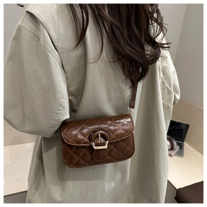 Detail of dark brown quilted crossbody bag featuring glossy finish and retro metal buckle