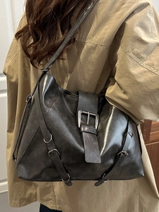 Retro large-capacity black faux leather tote bag with silver buckle and straps shown on model