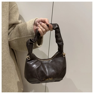Dettaglio della borsa a mano marrone scuro con design a pieghe e logo dorato