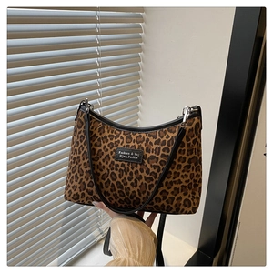 Dettaglio della borsa tote leopardata con profili in ecopelle ed etichetta del brand