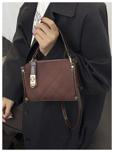 Gros plan du sac matelassé marron avec fermoir métallique et texture daim douce