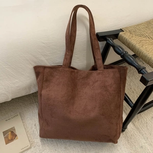Detailed texture of a brown corduroy tote bag in a cozy home setting with magazines