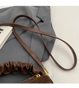 Détail du sac à bandoulière marron avec sangle réglable et boucle en métal doré