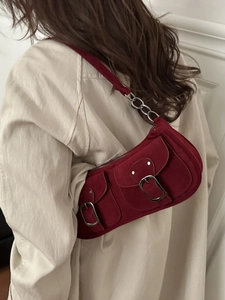 Deep red suede baguette bag with double pockets and silver chain strap on model