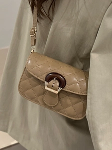 Quilted beige crossbody flap bag with tortoiseshell clasp and adjustable strap