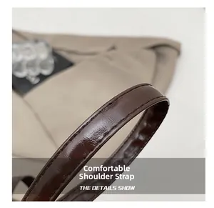 Dettaglio della comoda tracolla in pelle marrone scuro con cuciture precise su una borsa