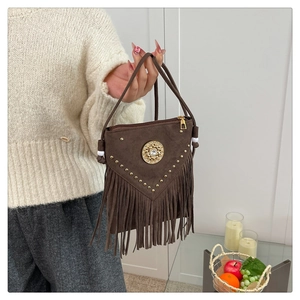 Detailed view of dark brown suede handbag with golden rivets and long tassels decoration