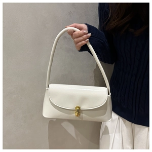 Detail of cream baguette bag featuring gold metal buckle and premium faux leather texture