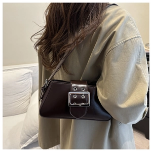 Détail d'un sac d'épaule en cuir marron foncé avec boucle argentée et décor de sangle
