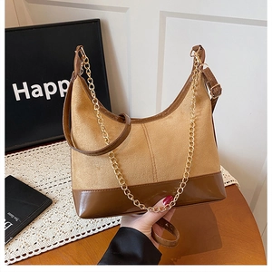 Dettaglio della borsa tote in pelle scamosciata marrone e PU con catena dorata