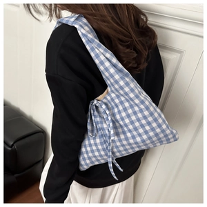 Detailed view of a blue and white gingham tote bag with a decorative side bow strap