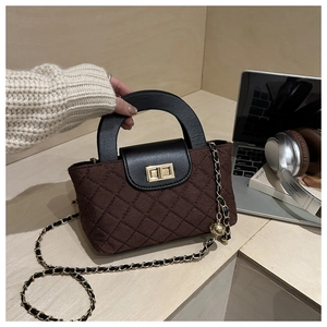 Détail d'un sac seau matelassé marron avec fermoir doré sur fond de style de vie