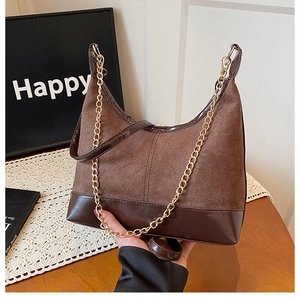 Dettaglio borsa hobo marrone retrò in patchwork di pelle scamosciata e catena d'oro