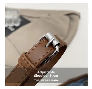 Detail of adjustable brown leather shoulder strap with silver buckle and fine stitching