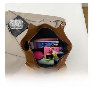 Detailed interior of a large brown tote bag showing capacity for a tablet and accessories