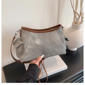Detail of grey washed canvas bag with brown leather trim and adjustable side pockets