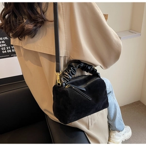 Détail du sac Boston en daim noir avec poignée froncée et garniture dorée chic