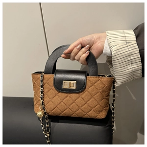 Détail de la laine matelassée et de la chaîne à boule dorée sur le sac à main marron