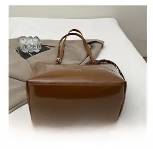 Detail view of the wide wear-resistant bottom on this brown high-capacity tote bag