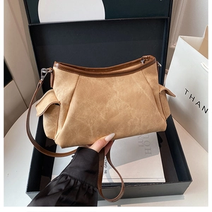 Close-up of khaki suede crossbody bag with pleated details and brown leather trim