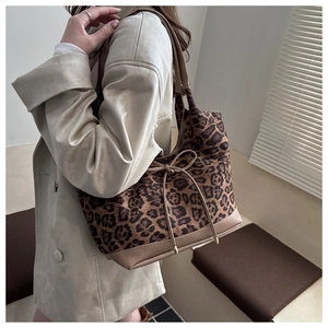 Detailansicht einer Leopard-Tragetasche mit braunen Lederakzenten und Schleifendetail
