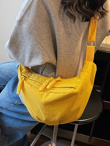 Bright yellow nylon crescent crossbody bag with woven zipper and adjustable strap