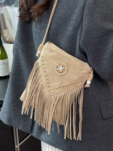 Brown suede bohemian crossbody bag with tassel fringe and gold rivet details
