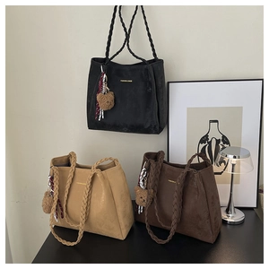 Detailed view of large tote bags with woven handles and cute plush bear pendants