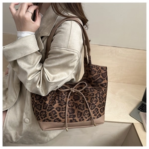 Detail der Leopard-Tasche mit braunem Kunstleder-Besatz und dekorativer Schleife am Henkel