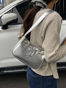 Silver metallic shoulder bag with gold eyelets and drawstring in a modern vintage style