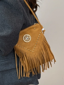 Vintage bohemian fringe crossbody bag in mustard suede with stud details on grey coat