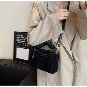 Détail du sac oreiller en daim noir avec poignée nuage froncée et bandoulière en cuir