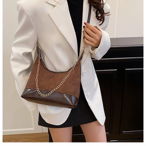 Dettaglio borsa sottospalla patchwork marrone scuro con catena dorata e pelle scamosciata