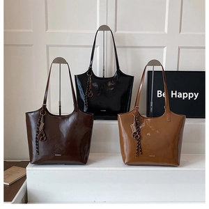 Detailed display of glossy tote bags in black, dark brown, and caramel finishes