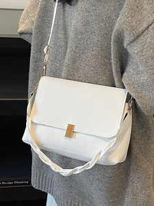 Sac bandoulière blanc en similicuir avec fermoir doré et anse tressée sur un modèle