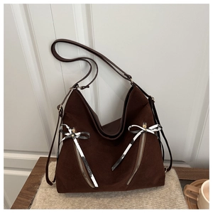 Detail of dark brown matte Hobo bag featuring decorative striped bows and gold zippers