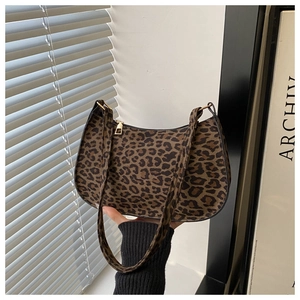 Close-up of leopard print baguette bag with metal zipper and slim shoulder strap detail