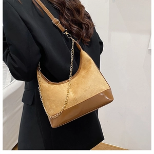 Dettaglio della borsa hobo con patchwork in pelle scamosciata marrone e catena dorata