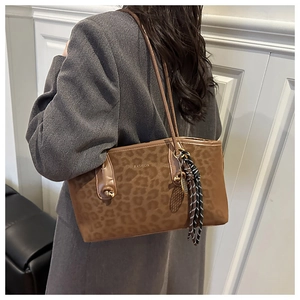 Détail du sac cabas imprimé léopard avec pendentif en corde à rayures noires et blanches