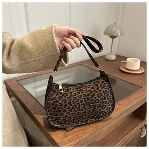 Detail of leopard print underarm bag featuring soft texture and gold zipper hardware