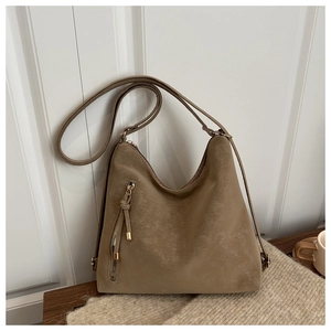Gros plan d'un sac hobo kaki mat avec un détail de fermeture éclair verticale décorative